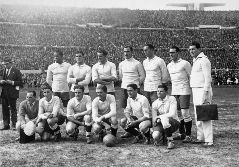 The Uruguay team prior to the FIFA World Cup Semi-Final against Yugoslavia at the Estadio Centenario in Montevideo, 27th July 1930. Uruguay won 6-1. Back row (left-right): Jose Leandro Andrade, Alvaro Gestido, Jose Nasazzi, Enrique Ballesteros, Ernesto Mascheroni, Lorenzo Fernandez, Luisito Greco (masseur). Front row: Ernesto Figoli (masseur), Pablo Dorado, Hector Scarone, Pelegrin Anselmo, Pedro Cea, Santos Iriarte. (Photo by Bob Thomas/Popperfoto via Getty Images/Getty Images)